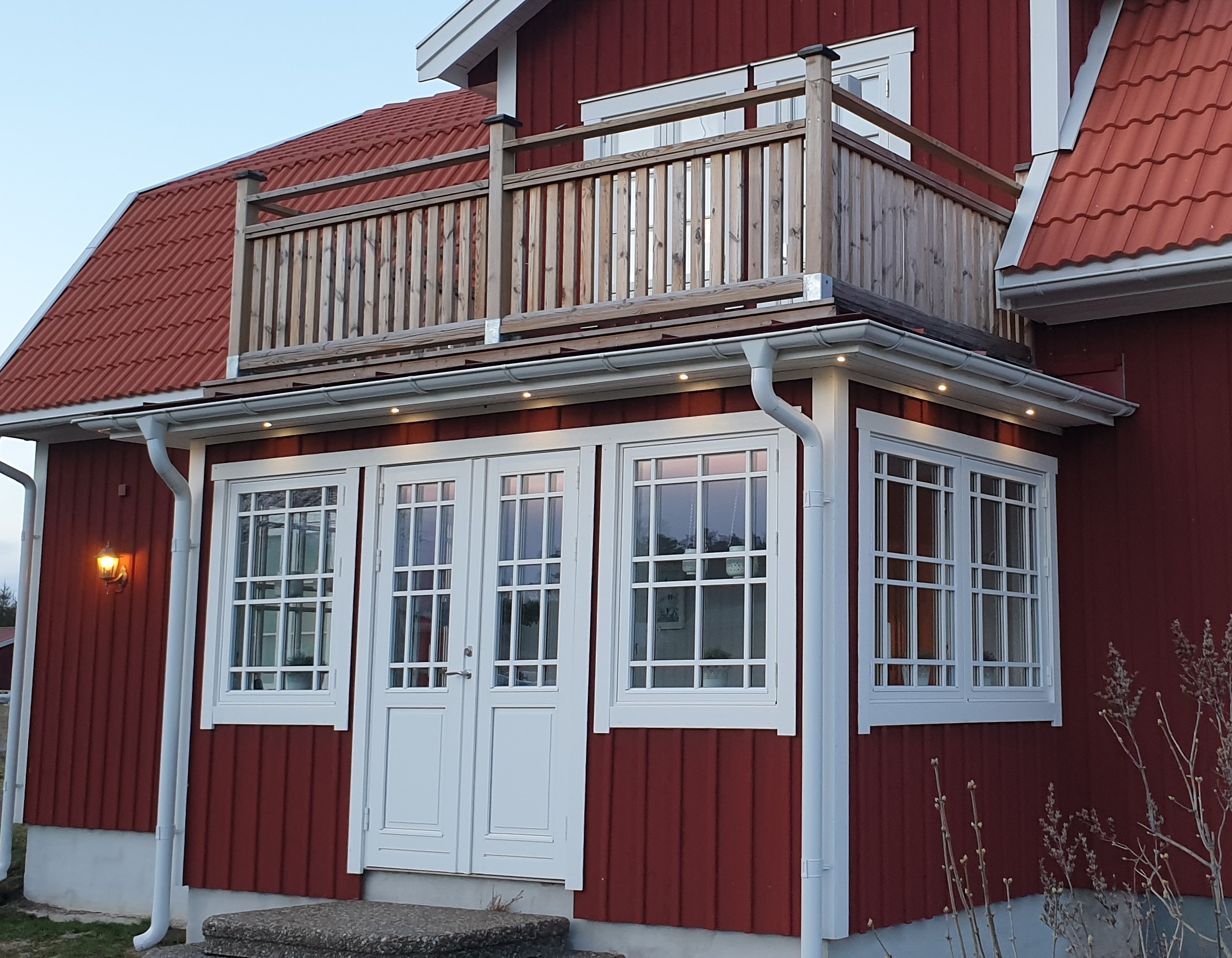 Veranda förstukvist med gammaldags ytterdörr och fönster med fast spröjs