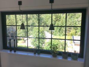 Fast svart SW17 fönster med fast båge och löstagbar träspröjs ute Fast svart SW17 fönster med fast båge och löstagbar träspröjs ute