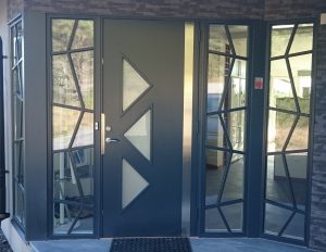 Specialdesignad paneldörr med dekoration i aluminium Specialdesignad paneldörr med dekoration i aluminium och sidoljus med specialdesignad fast spröjs.